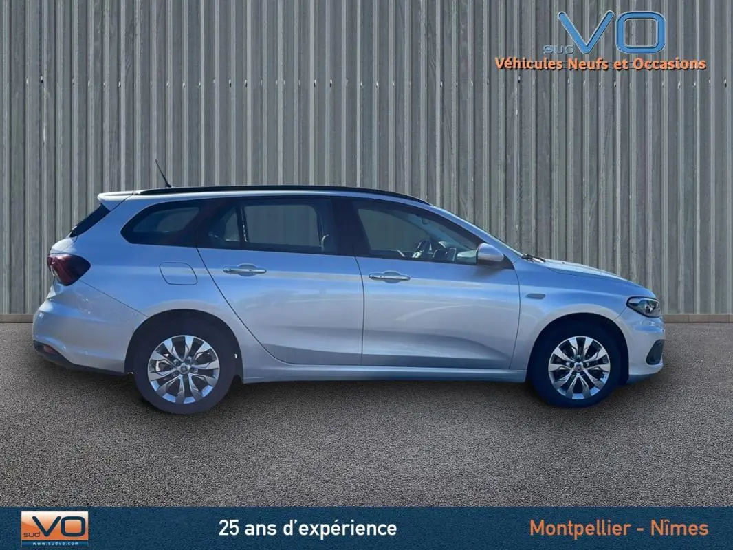 Profil côté gauche d'une FIAT Tipo Station Wagon Business gris métallisé avec jantes alliage 16 pouces sur sol goudronné.