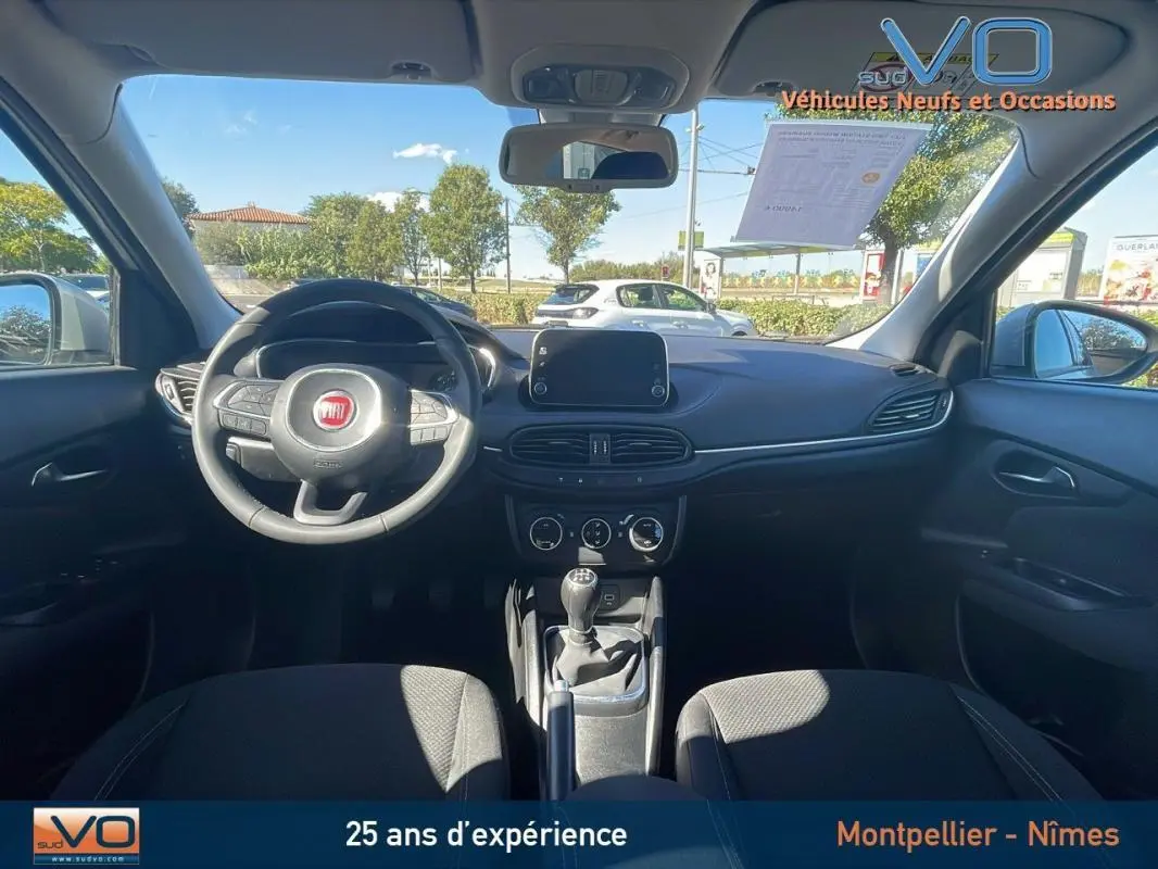Intérieur noir de la Fiat Tipo Station Wagon 2018, vue frontale du tableau de bord avec volant et écran tactile.