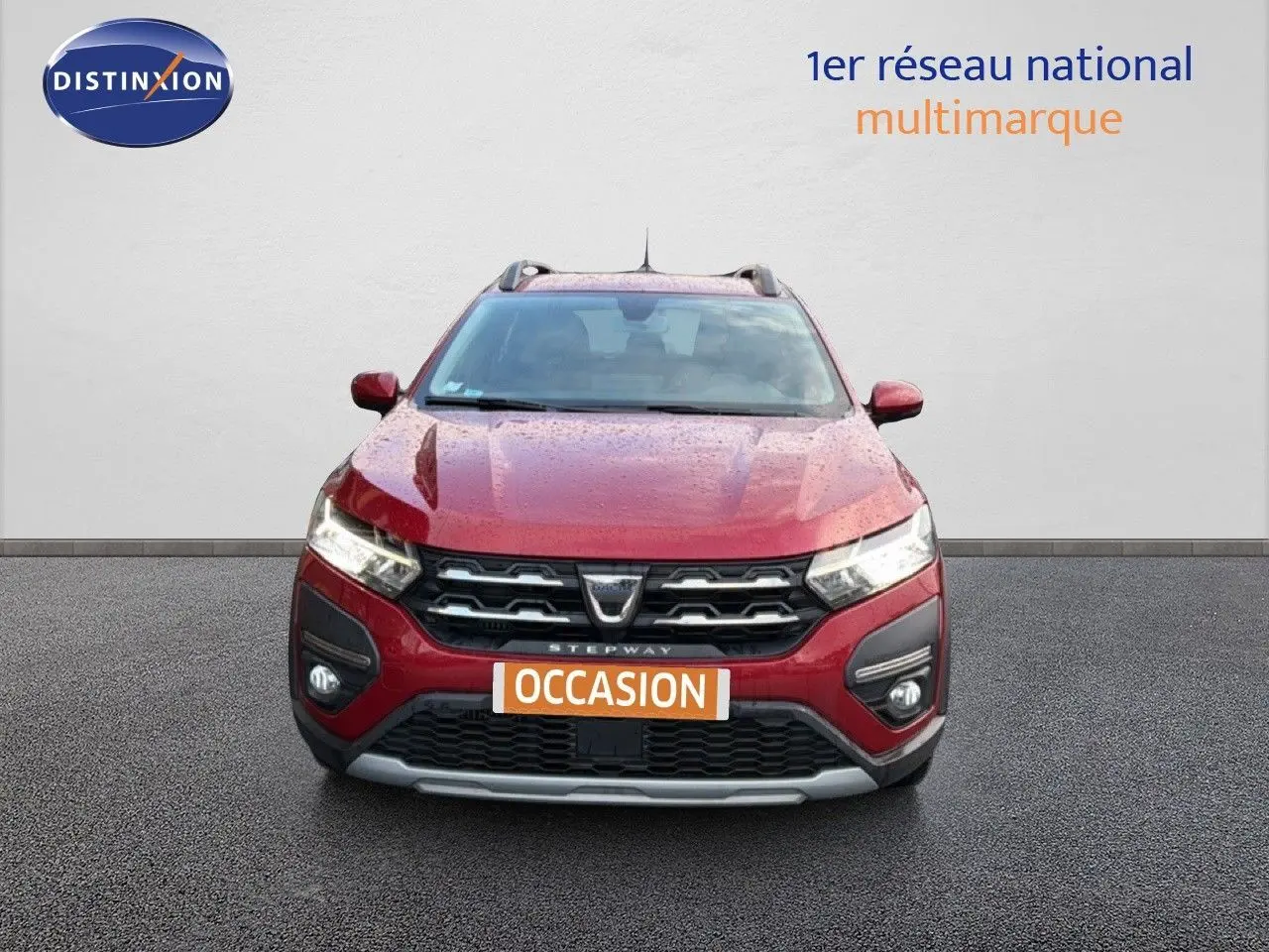Vue avant d'une Dacia Sandero Stepway rouge fusion 2021 avec calandre noire et plaques "OCCASION" visibles.