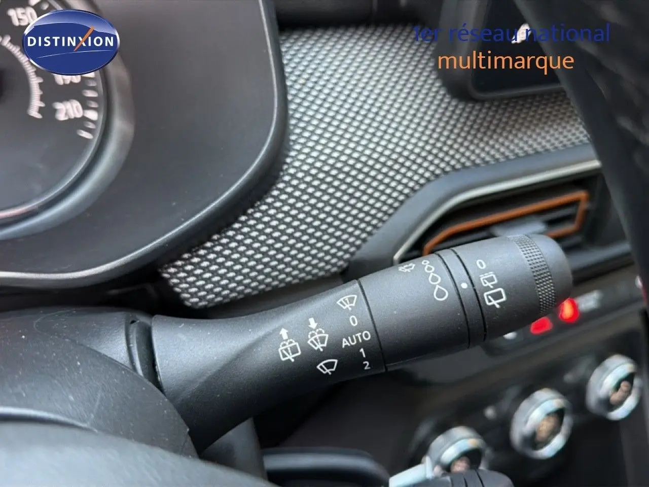 Gros plan sur la commande des essuie-glaces dans l’habitacle d’une Dacia Sandero Stepway 2021 rouge fusion.