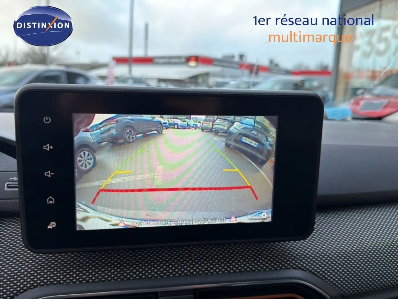 Écran de caméra de recul affichant l’arrière d’une Dacia Sandero Stepway rouge fusion en stationnement.