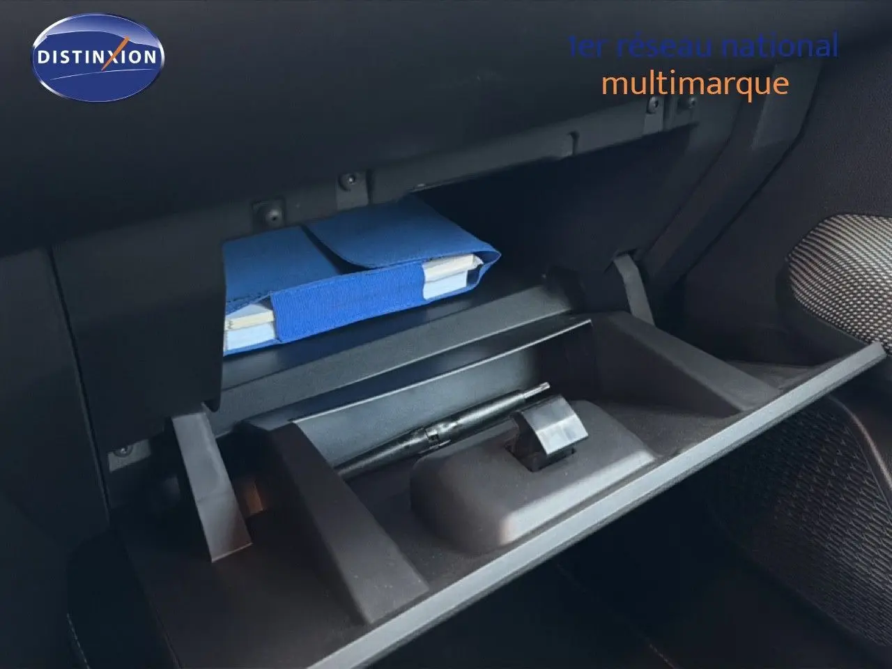 Gant de boîte à gants ouvert avec un carnet bleu et un stylo à l'intérieur d'une Dacia Sandero Stepway 2021.