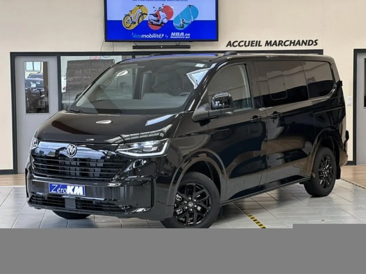 Vue 3/4 avant du Volkswagen Transporter T7 ProCab noir minuit avec jantes alliage noir brillant en showroom.