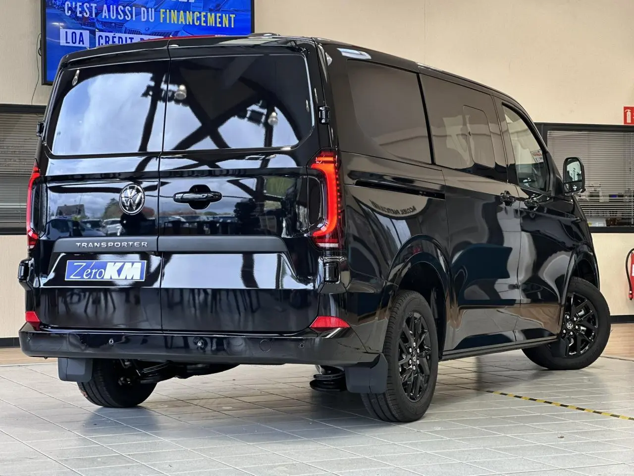 Vue 3/4 arrière droite du Volkswagen Transporter T7 ProCab noir minuit avec feux arrière LED et jantes alliage noires.