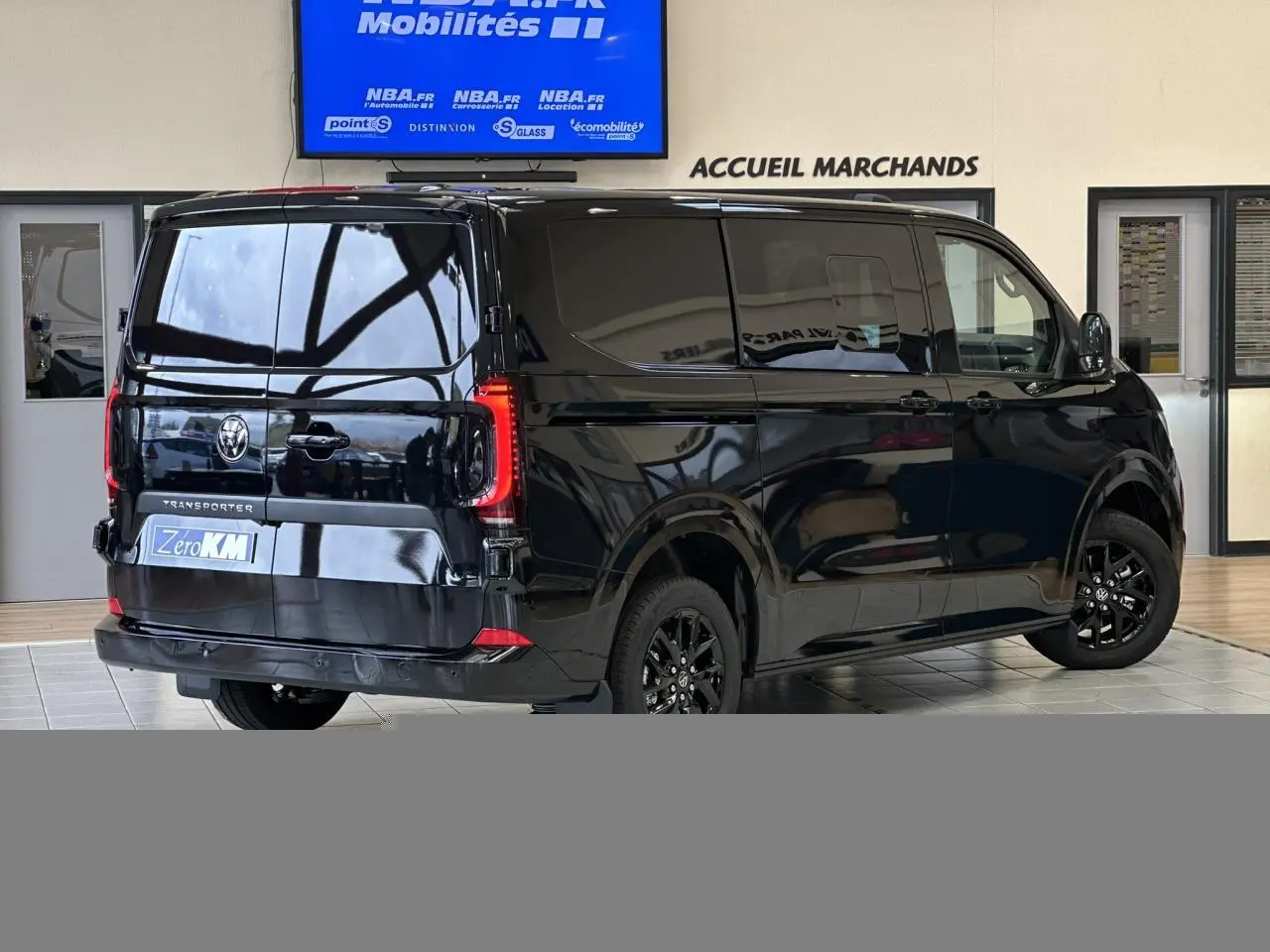 Vue 3/4 arrière droite du Volkswagen Transporter T7 ProCab noir Minuit avec jantes alliage noir brillant et feux arrière LED.