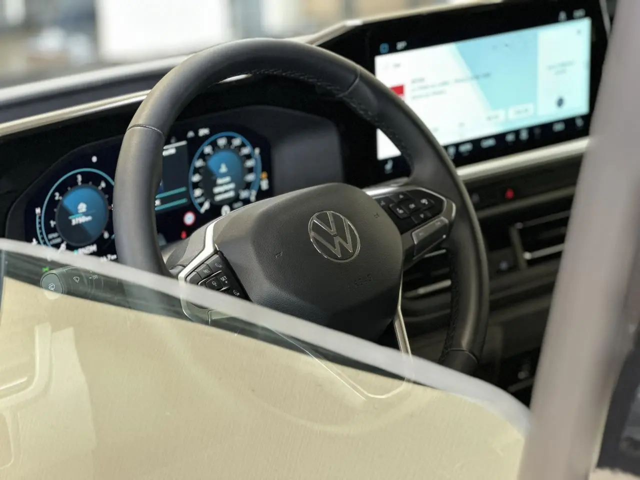 Vue intérieure centrée sur le volant multifonction noir et l'écran tactile large du Volkswagen Transporter T7.