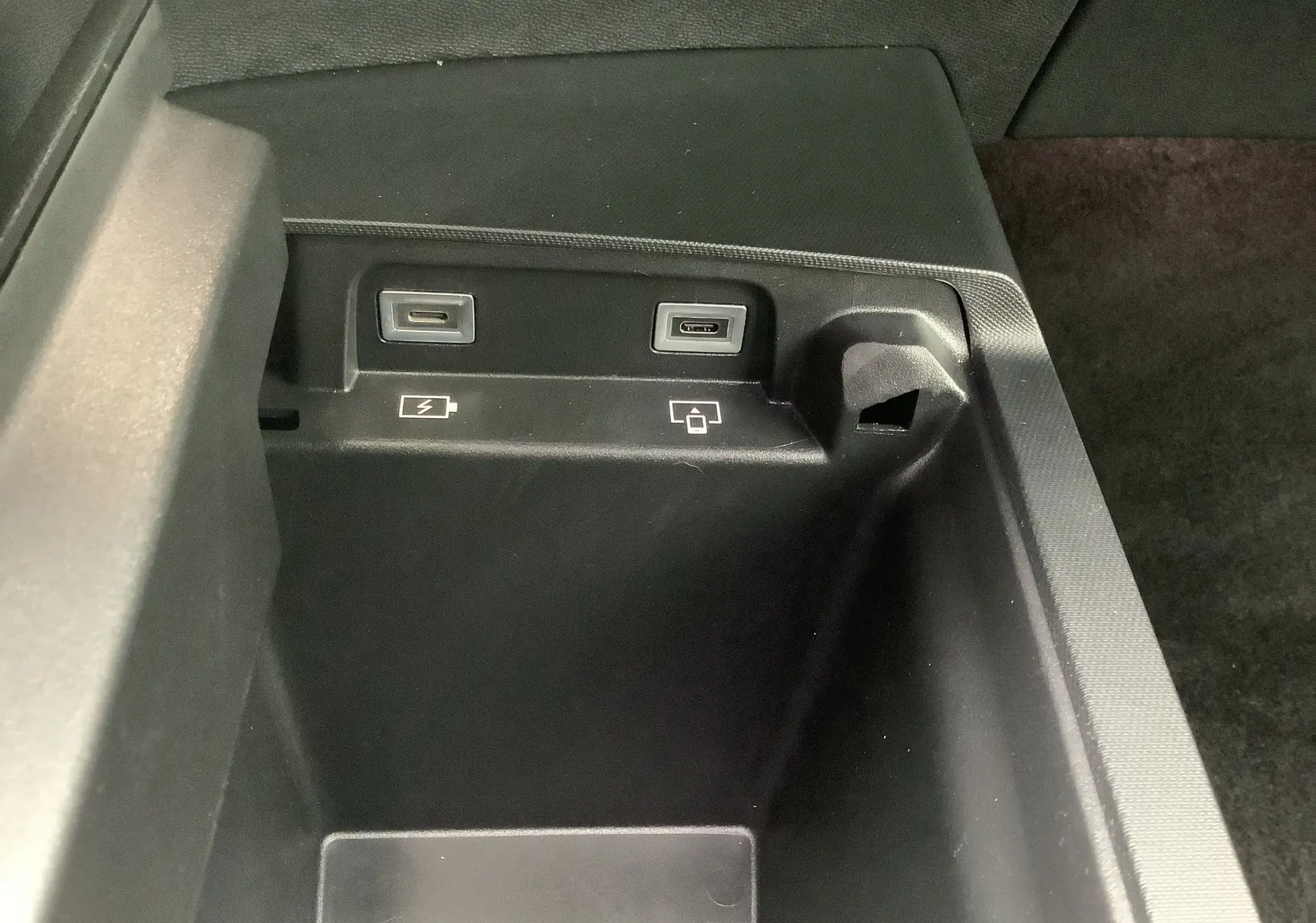 Vue rapprochée de la console centrale noire du Peugeot 3008 Hybrid 2024 montrant deux ports USB-C pour charge et données.