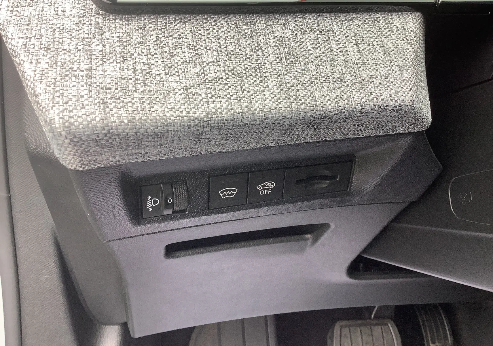 Détail des commandes sous le tableau de bord côté gauche du Peugeot 3008 blanc Okenite hybride 2024.