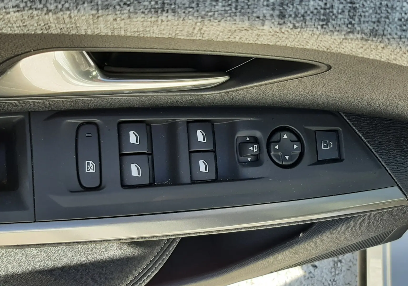 Gros plan sur la commande des vitres et rétroviseurs côté conducteur d’un Peugeot 3008 blanc Okenite 2024.