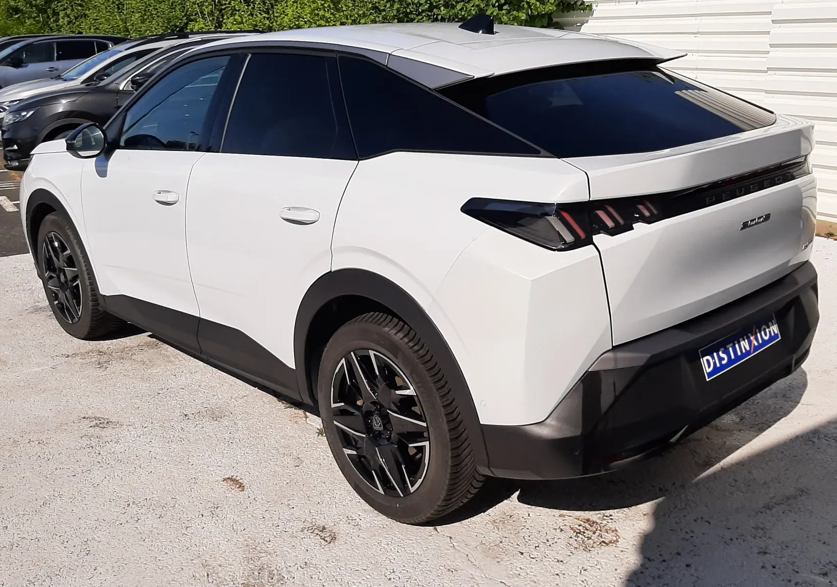 Peugeot 3008 Hybrid blanc Okenite vue 3/4 arrière droit, vitres teintées et jantes noires distinctives.