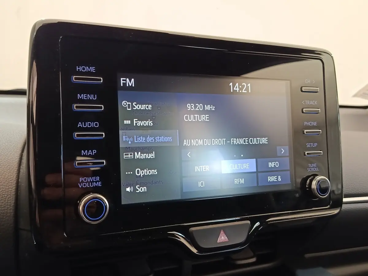 Écran tactile central de la Toyota Yaris hybride 2022 affichant la radio FM sur fond noir brillant.