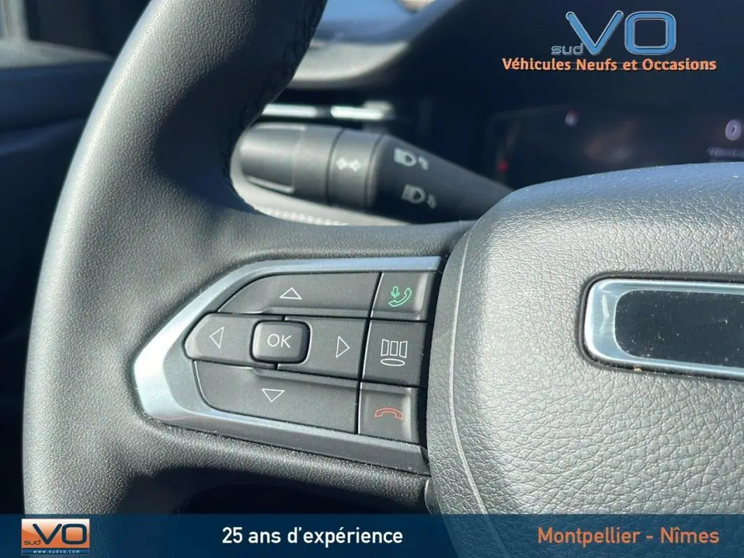 Gros plan sur les commandes gauche du volant du Jeep Compass noir 2023, avec boutons de navigation et appel.