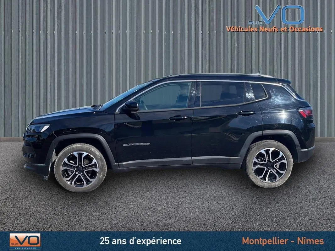 Profil côté gauche d'un Jeep Compass noir 2023 avec jantes 18 pouces, barres de toit et rétroviseurs électriques rabattables.