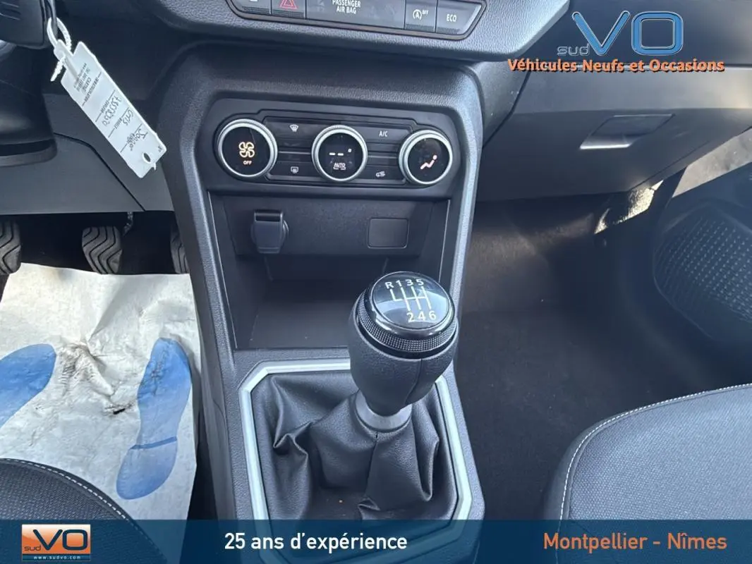 Gros plan sur le levier de vitesses manuel noir et la console centrale du Dacia Jogger gris 2025, intérieur moderne et fonctionnel.