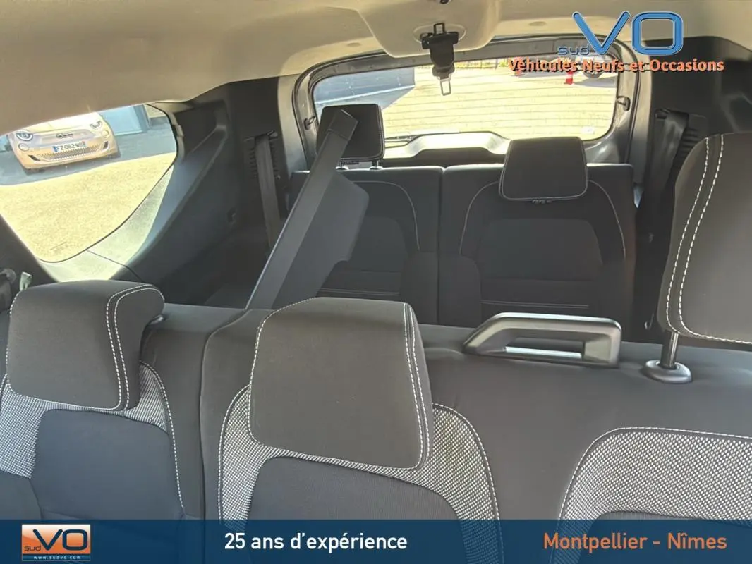 Vue intérieure arrière du Dacia Jogger gris 7 places montrant les sièges avec appuie-têtes et un siège rabattable.