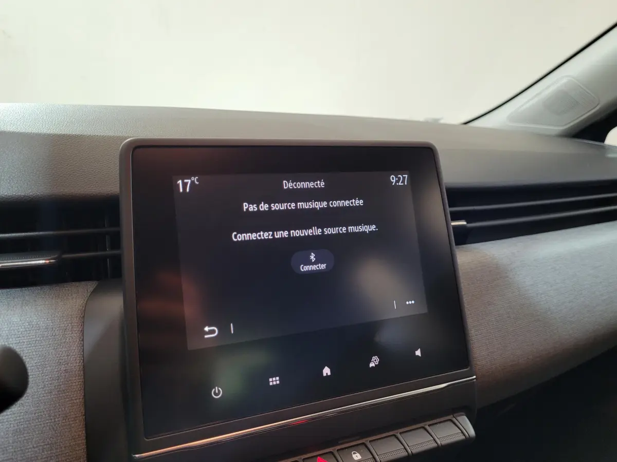 Écran tactile central affichant une interface de connexion Bluetooth dans l'habitacle d'une Renault Clio gris foncé.