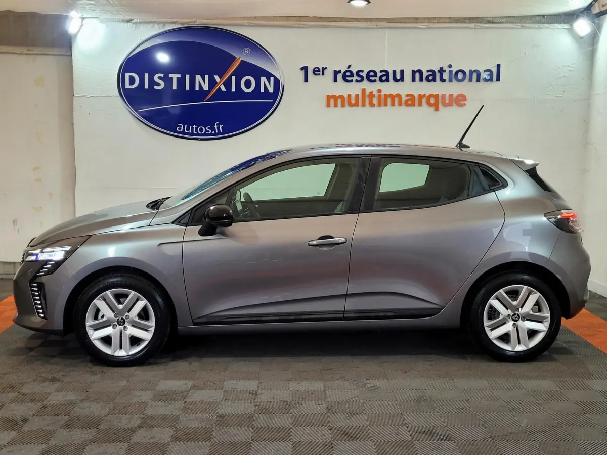 Profil droit de la Renault Clio gris foncé 2025 en intérieur, avec jantes alliage et feux LED avant visibles.