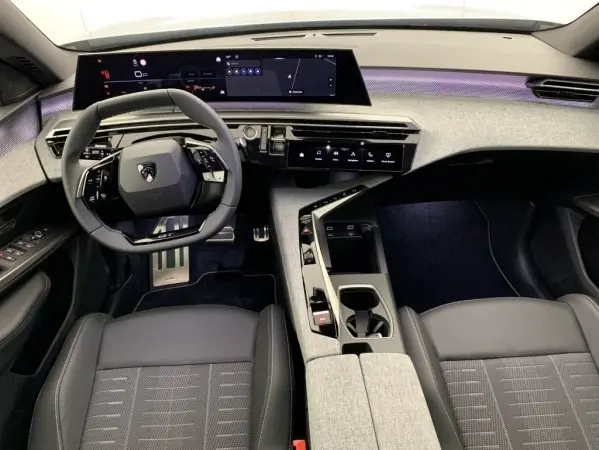 Vue intérieure avant du Peugeot 3008 1.2 Hybrid 145 GT avec tableau de bord numérique large et volant cuir multifonctions.