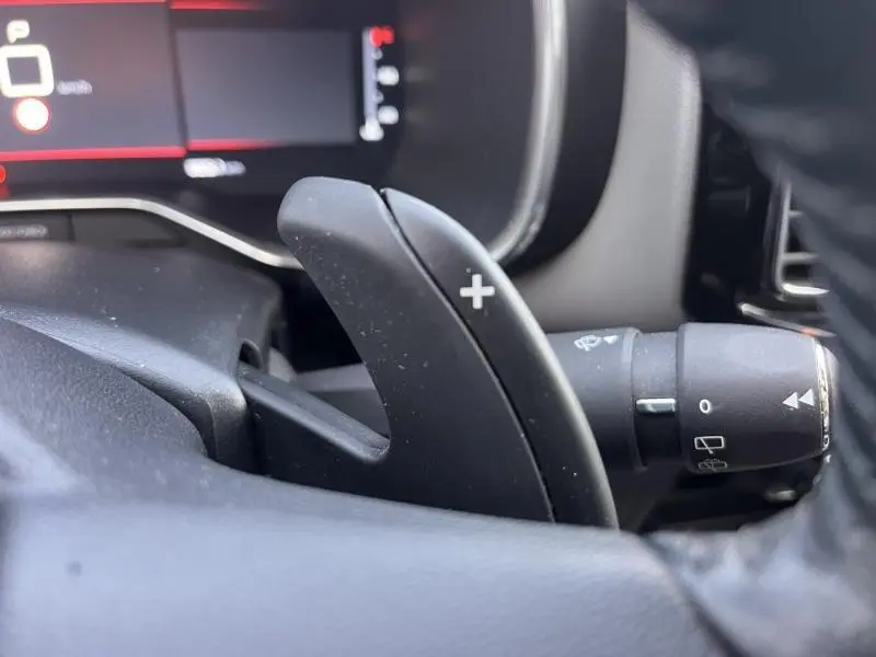 Gros plan sur la palette de changement de vitesse "+" côté droit du volant dans l'habitacle gris du Citroën C5 Aircross 2021.