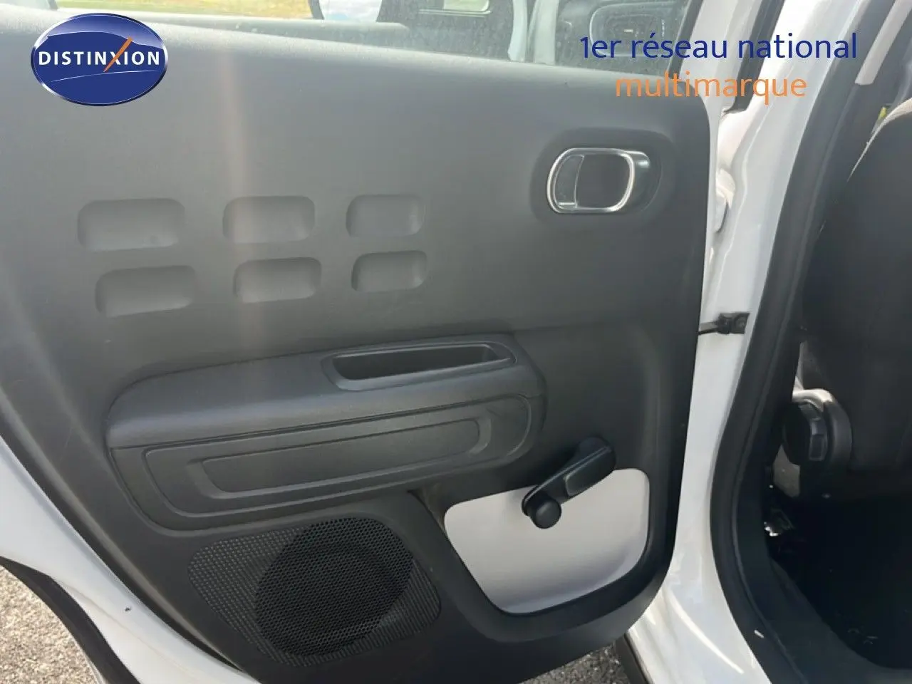 Vue intérieure côté gauche de la porte arrière blanche d'une Citroën C3 2018 avec poignée manuelle et haut-parleur intégré.