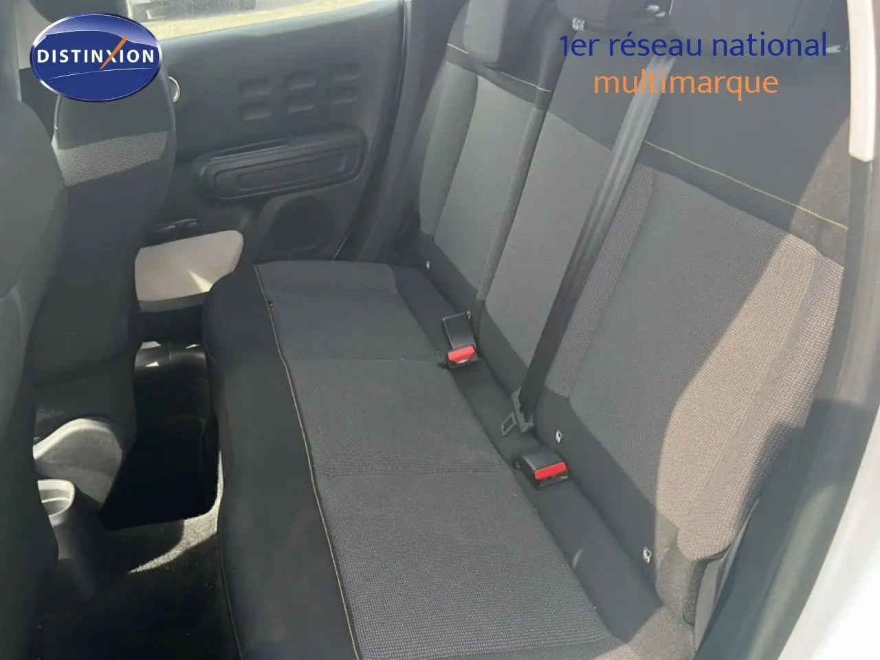 Vue intérieure côté droit montrant la banquette arrière en tissu gris foncé d'une Citroën C3 blanche de 2018.