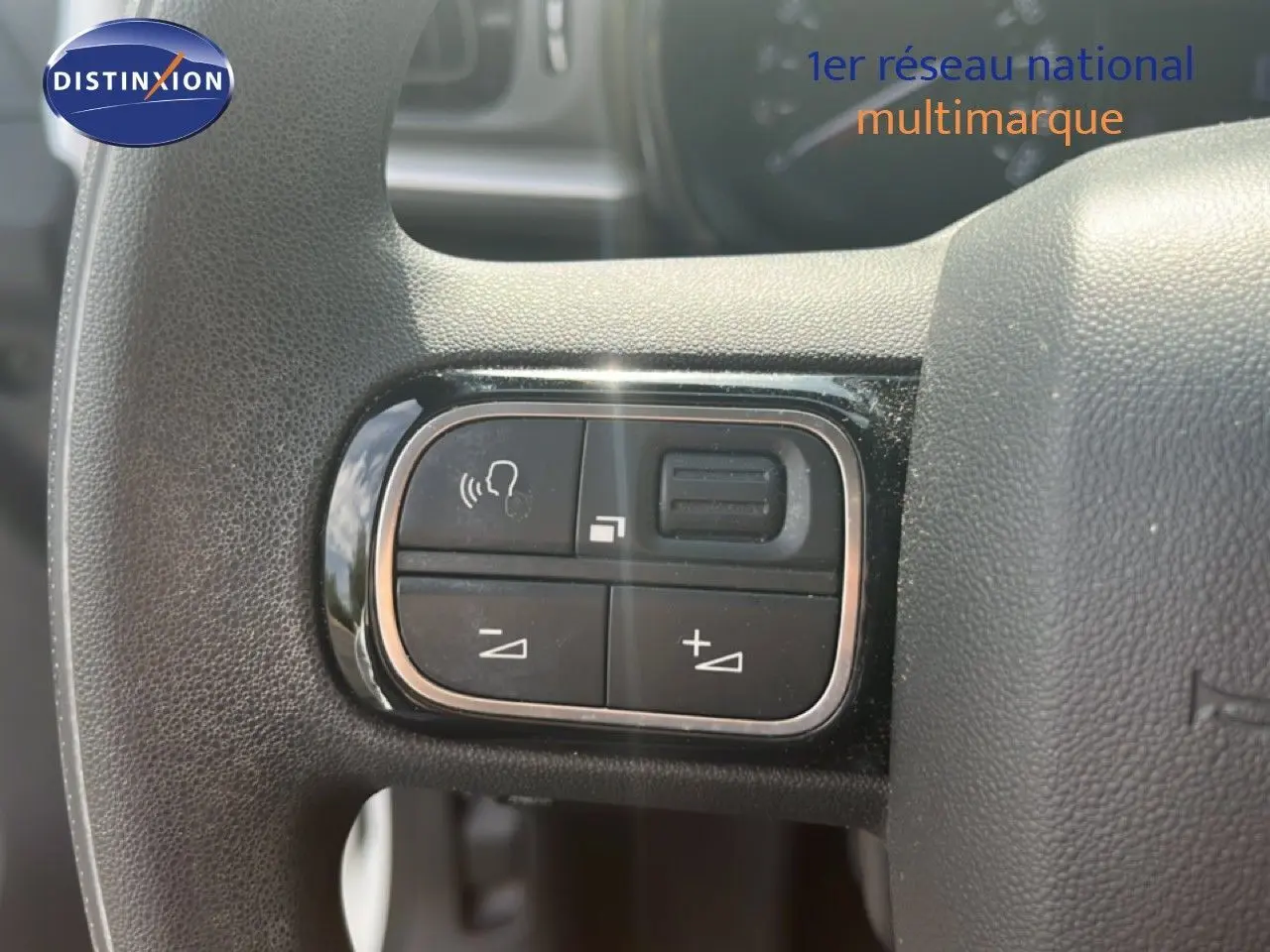 Gros plan sur les commandes vocales et volume au volant d'une Citroën C3 blanche essence de 2018.
