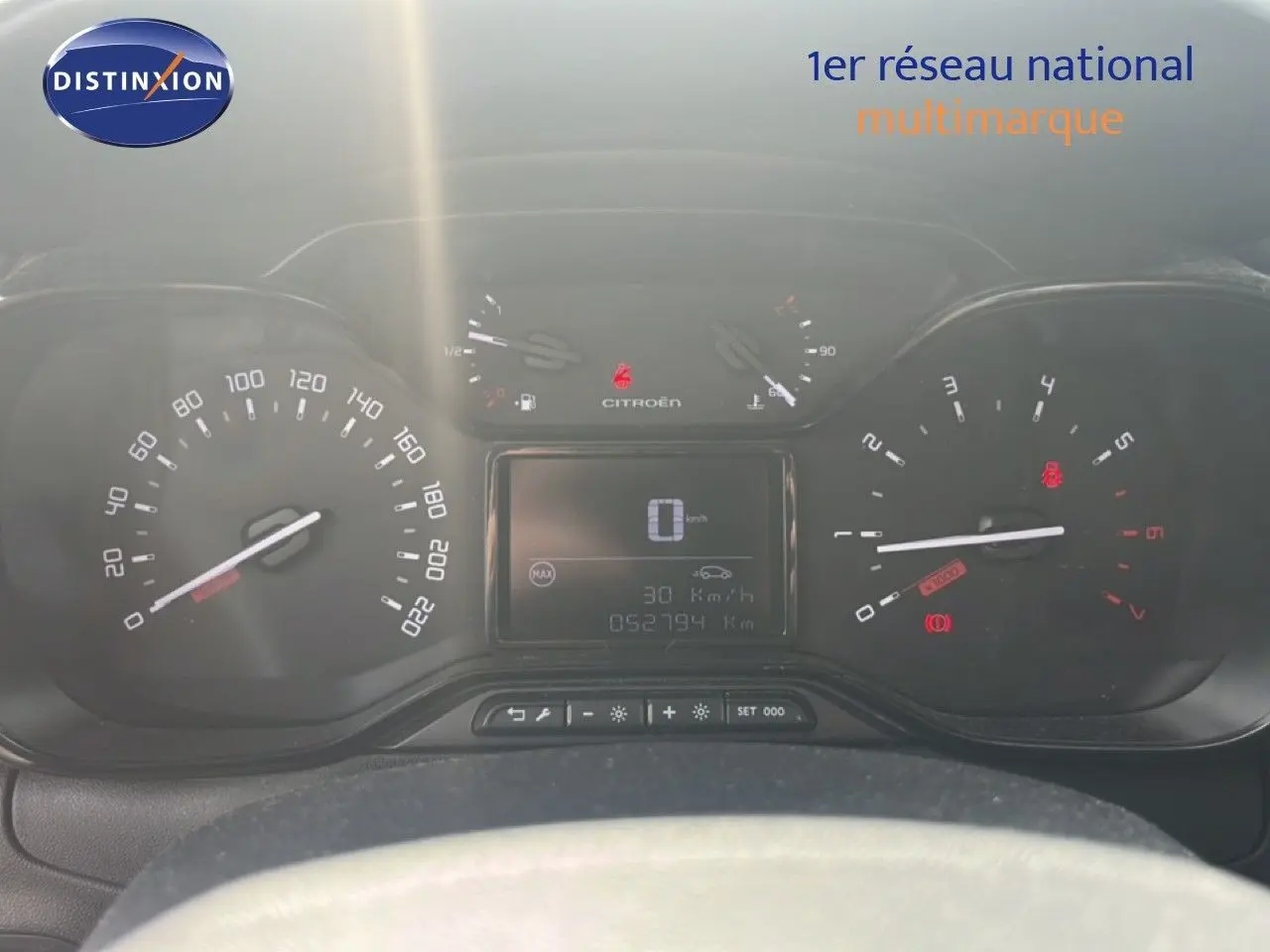 Vue rapprochée du tableau de bord de la Citroën C3 blanche 2018, affichant compteur et écran digital.