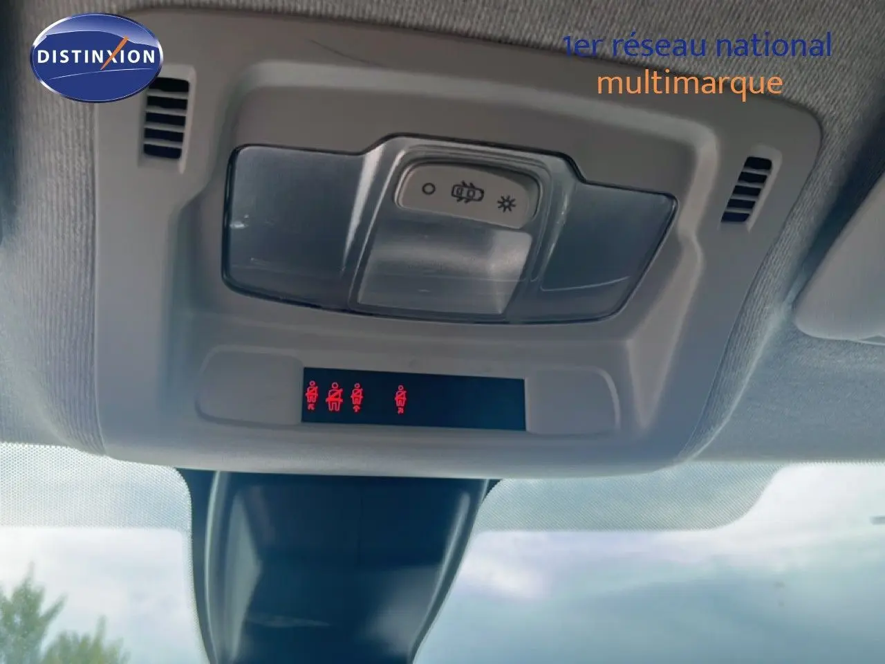 Vue intérieure du plafonnier de la Citroën C3 blanche 2018 avec commandes d’éclairage et indicateurs de ceinture allumés.