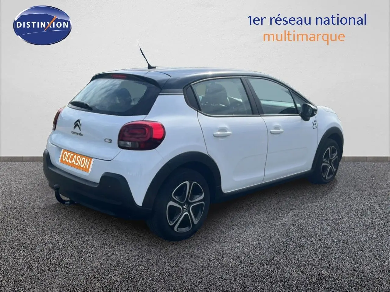 Citroën C3 blanc vue 3/4 arrière droit avec toit noir et jantes distinctives, en extérieur sur sol gris.