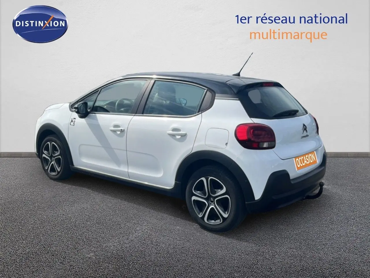 Citroën C3 blanc vue 3/4 arrière droit, toit noir, jantes alliage et feux arrière arrondis visibles.