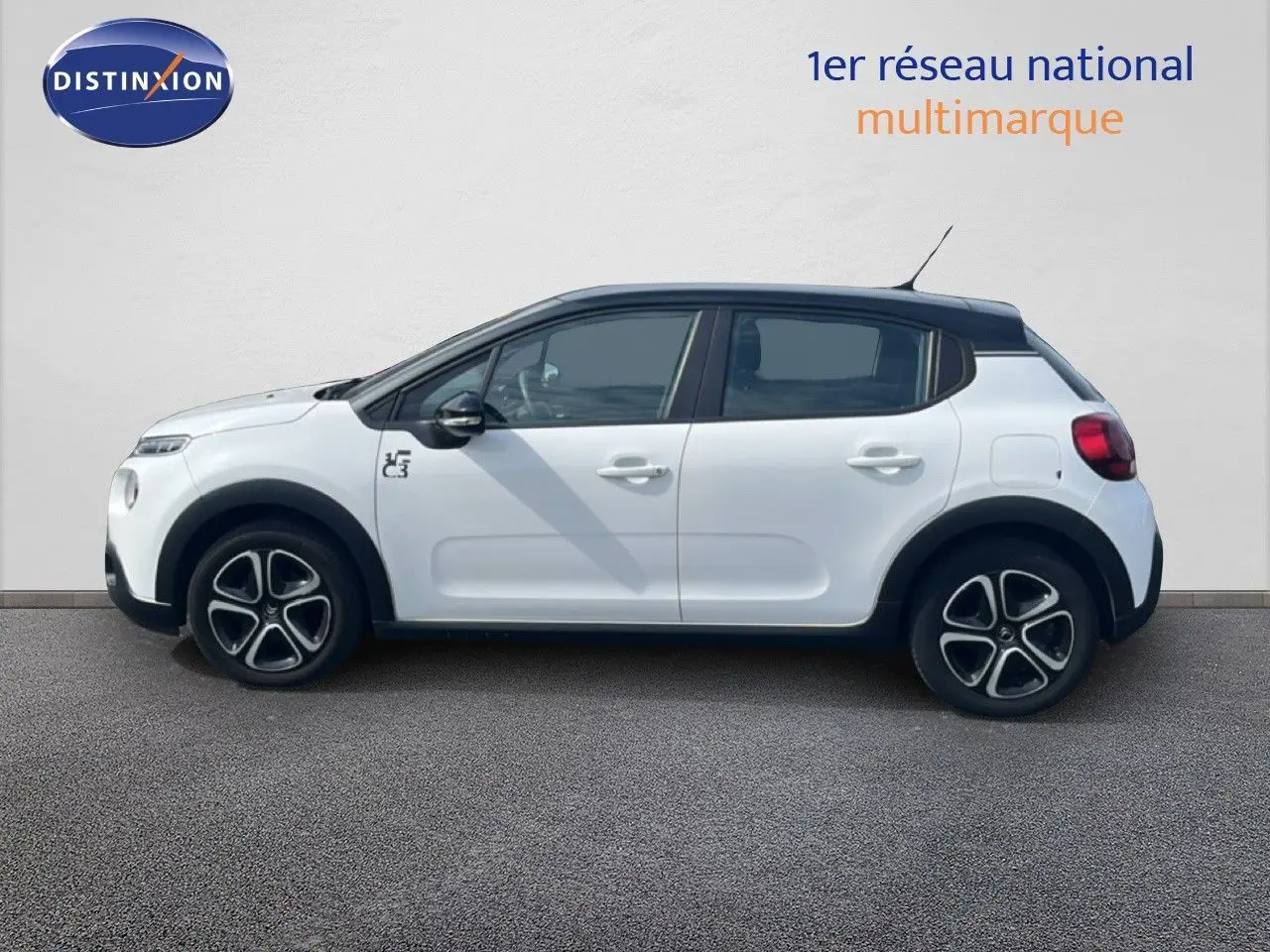Profil côté gauche d'une Citroën C3 blanche 2018 avec toit noir et jantes originales en alliage.