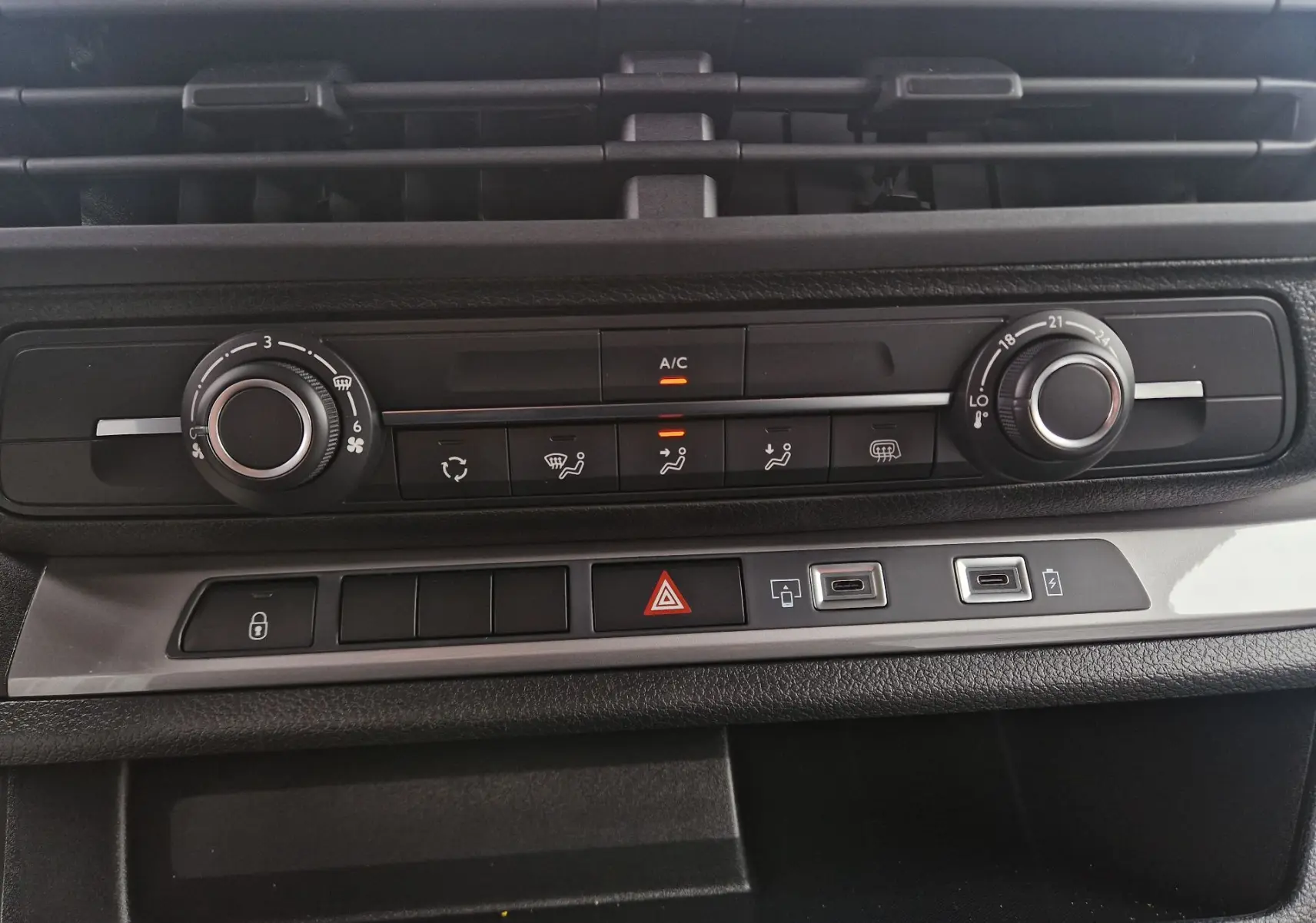 Vue rapprochée de la console centrale du Citroën Jumpy XL gris titane, montrant les commandes de climatisation et boutons multifonctions.