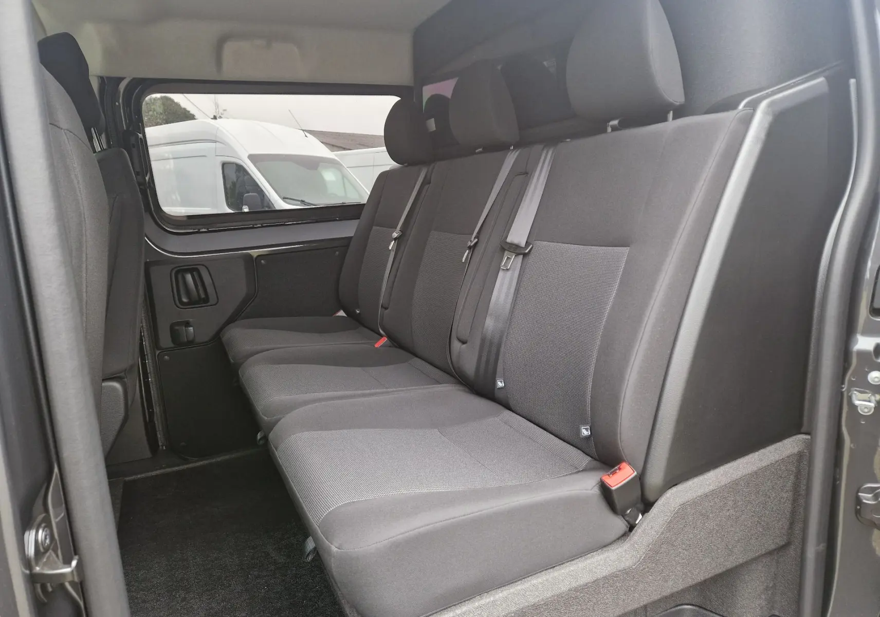 Vue intérieure côté droit des sièges arrière gris foncé du Citroën Jumpy Cabine Approfondie 2025, version 5 places.