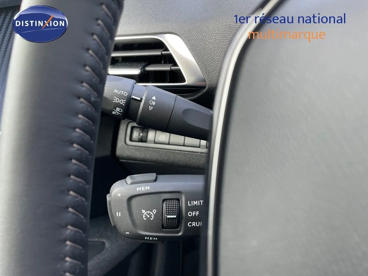 Gros plan sur les commandes de régulateur de vitesse et éclairage à gauche du volant d'un Peugeot 3008 bleu Célebès Métal.