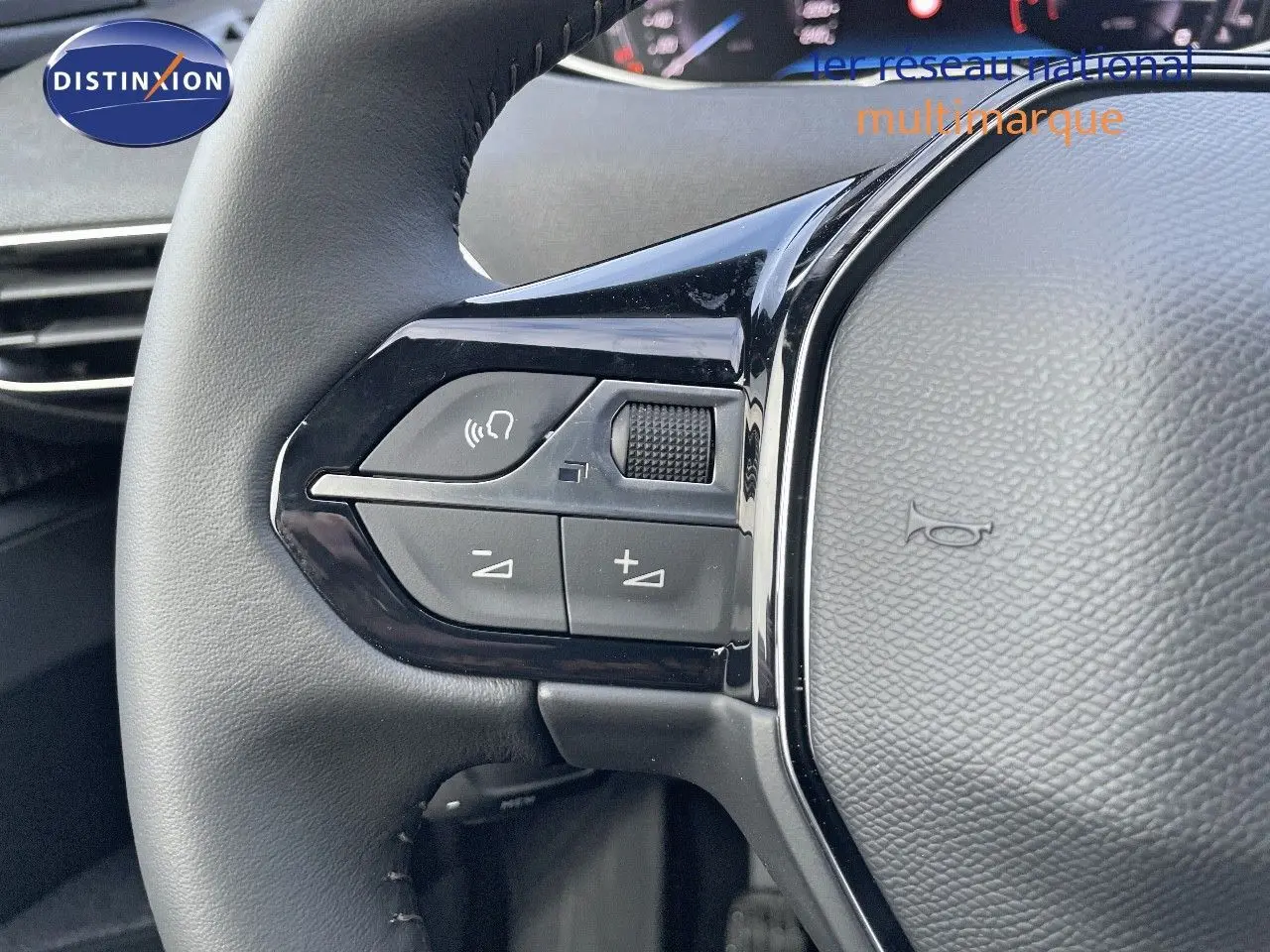 Gros plan sur les commandes gauche du volant en cuir noir du Peugeot 3008 bleu Celebes Metal 2023.