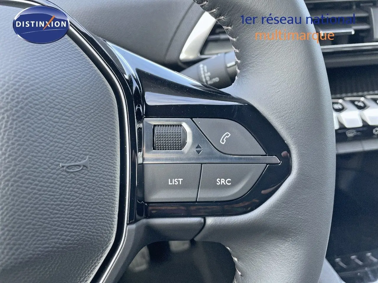 Gros plan sur les commandes du volant cuir gris du Peugeot 3008 2023, version essence Bleu Célèbes Métal.