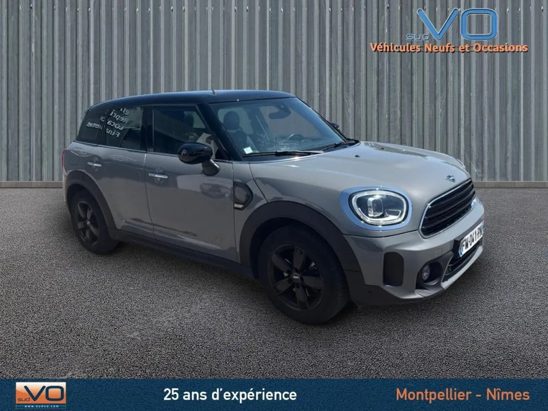 Vue 3/4 avant gauche d'une MINI Countryman gris clair avec toit noir et jantes alliage noires.