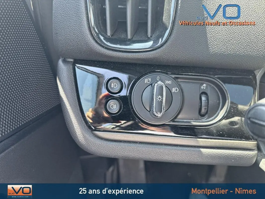 Gros plan sur le panneau de commande des phares et antibrouillard dans l'habitacle d'une MINI Countryman gris clair.