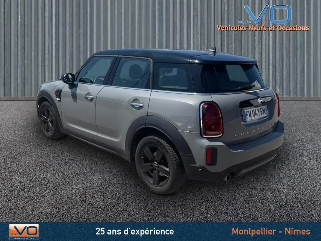 Vue 3/4 arrière droite d'une MINI Countryman gris clair avec toit noir et jantes alliage 17 pouces.