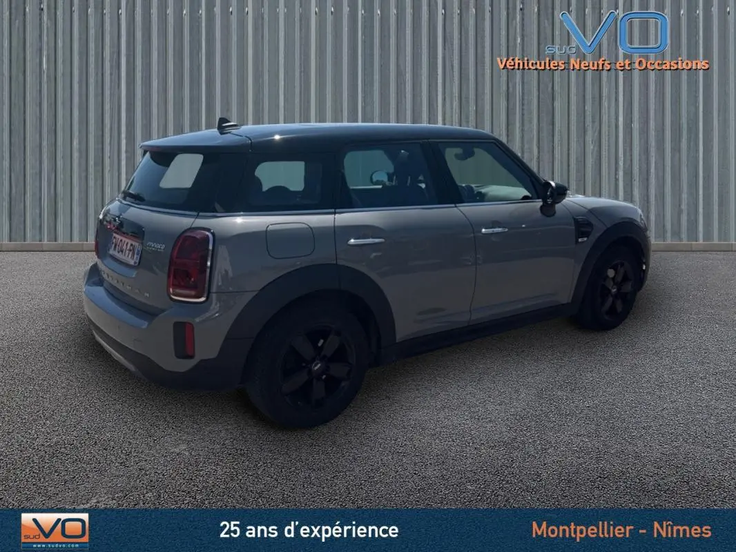 Vue 3/4 arrière droite d'une MINI Countryman gris clair avec toit noir et jantes alliage noires.