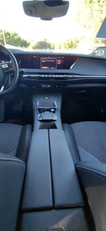 Vue intérieure avant du DS4 Hybride E-Tense 225 Bastille 2024, montrant la console centrale et le tableau de bord noir moderne.