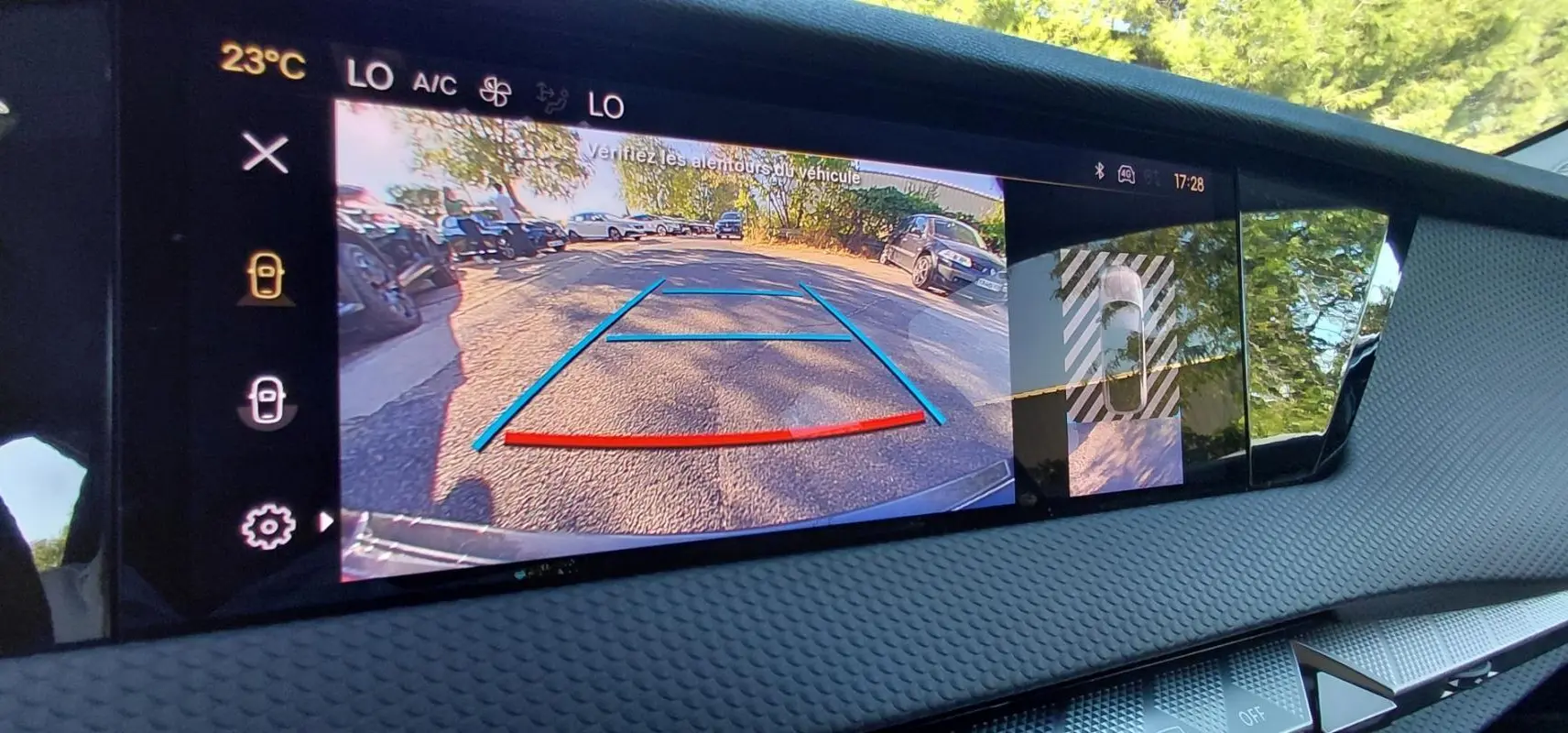 Écran intérieur du DS4 2024 Hybride E-Tense montrant la caméra de recul avec lignes de guidage colorées et vue 360° du véhicule.