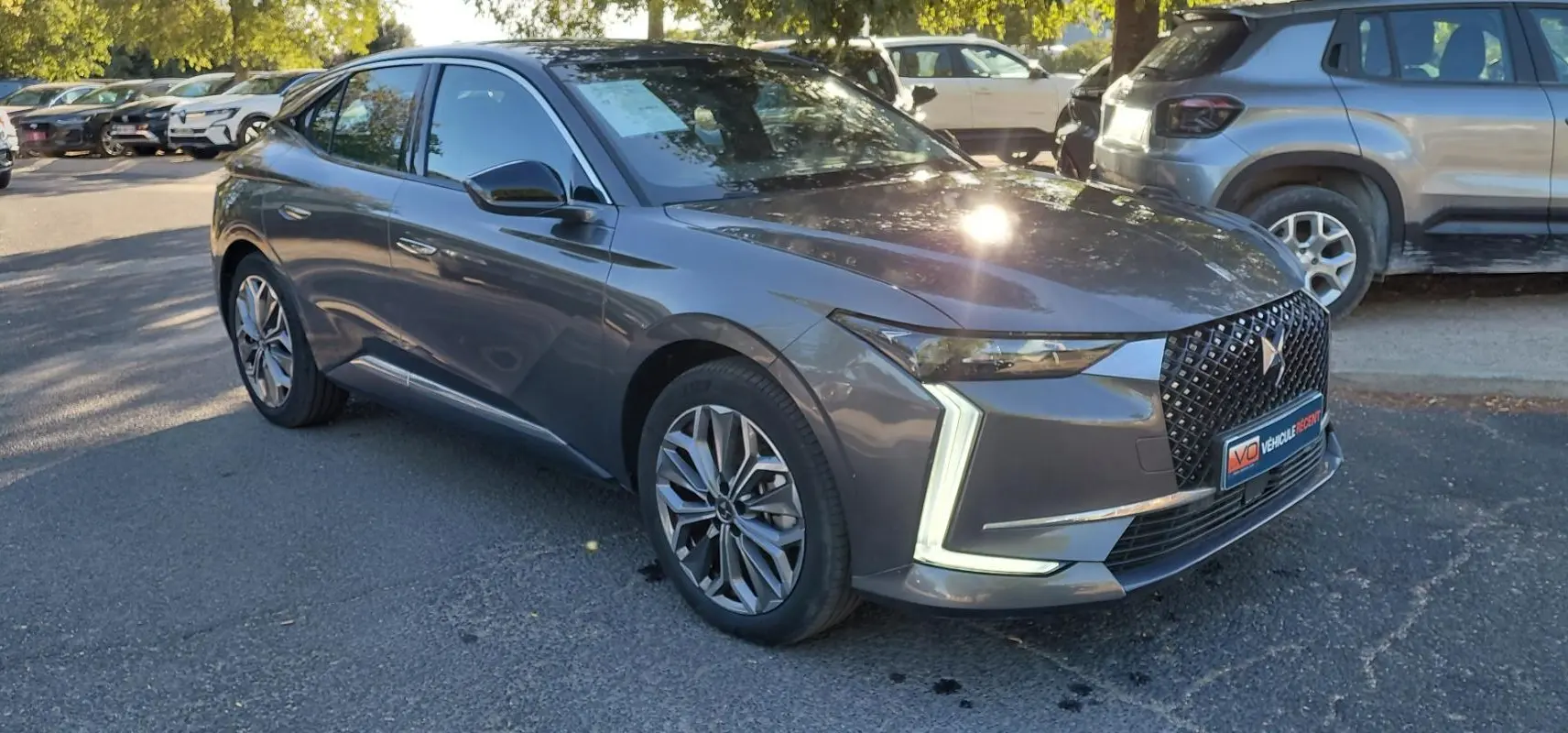 DS4 Hybride E-Tense 225 gris, vue 3/4 avant droit, avec signature lumineuse en forme de "L" distinctive.