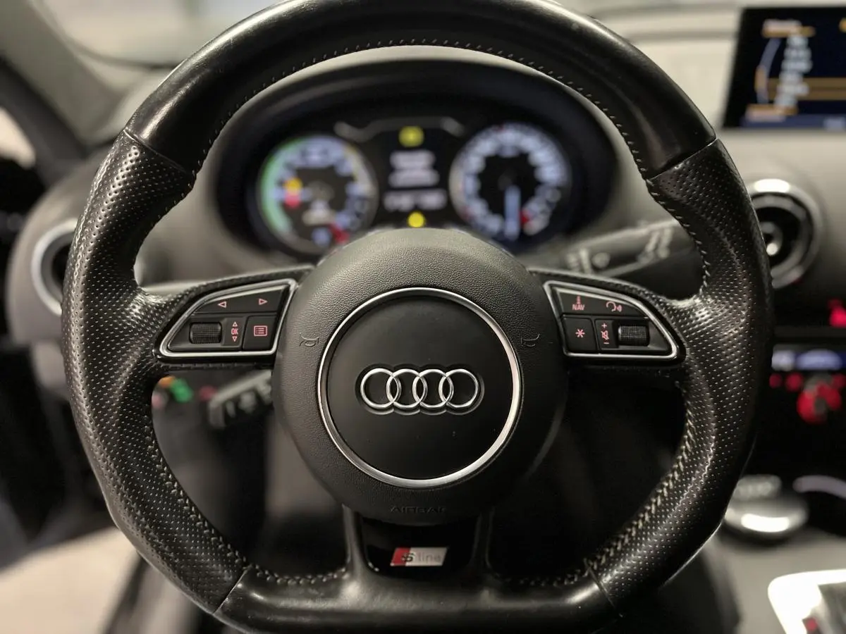 Volant sport en cuir perforé noir avec logo Audi et badge S line, intérieur de l'Audi A3 hybride rechargeable 2015.