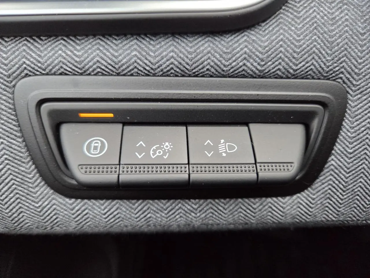 Gros plan sur les commandes de réglage d’éclairage et d’aide à la conduite sur la planche de bord grise d’une Renault Clio 2025.