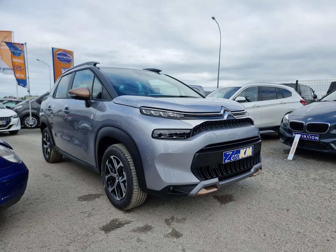 SUV Citroën C3 Aircross gris Artence en 3/4 avant droit avec coques de rétroviseurs bronze et jantes alliage diamantées.