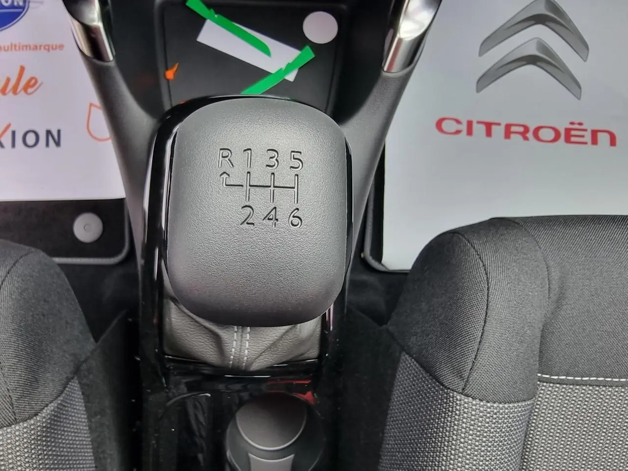 Vue rapprochée du levier de vitesses manuel gris du Citroën C3 Aircross 2022, avec sièges tissu noirs autour.