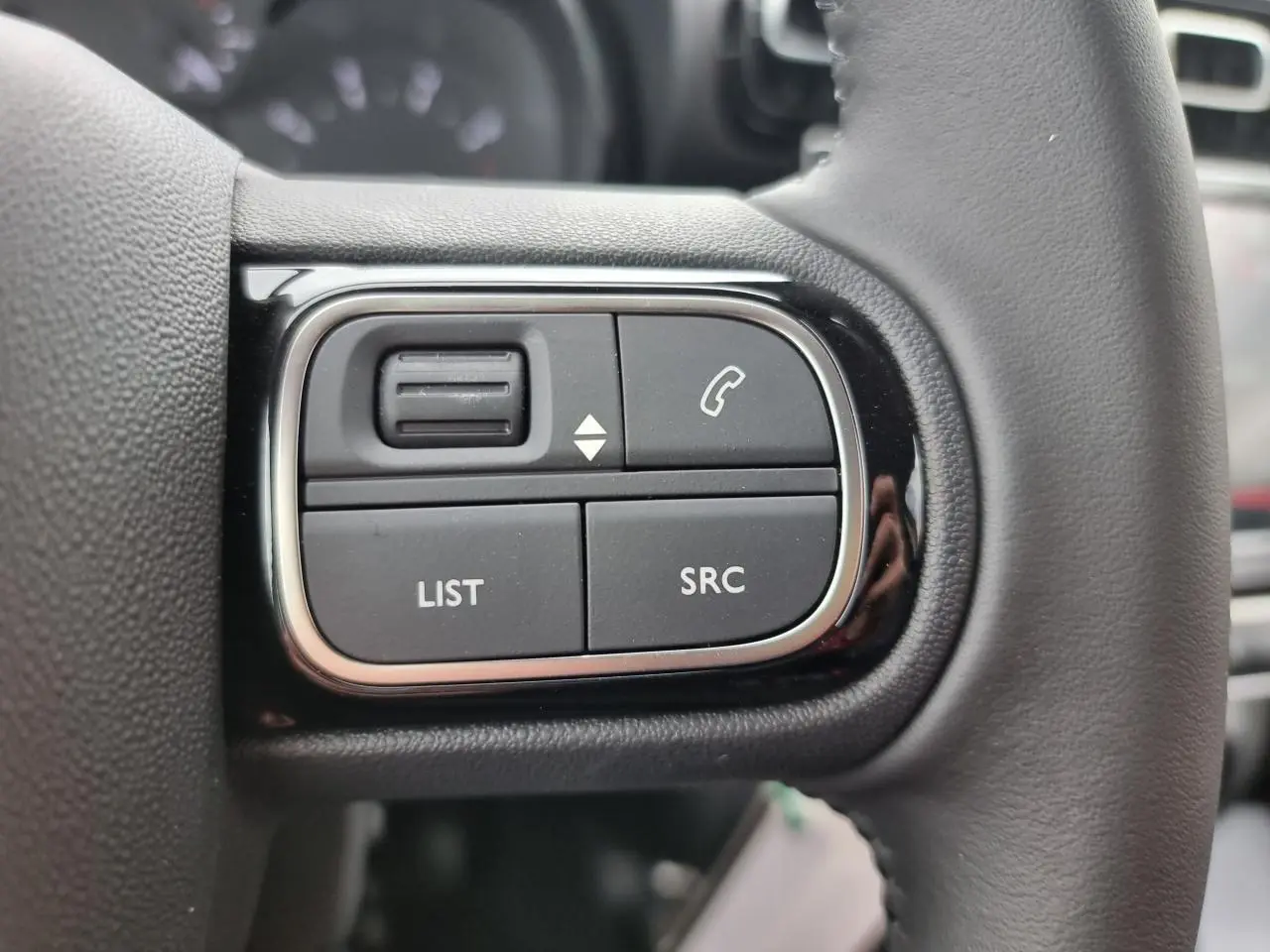 Gros plan sur les commandes multimédia au volant du Citroën C3 Aircross 2022, finition C-Series, intérieur noir.