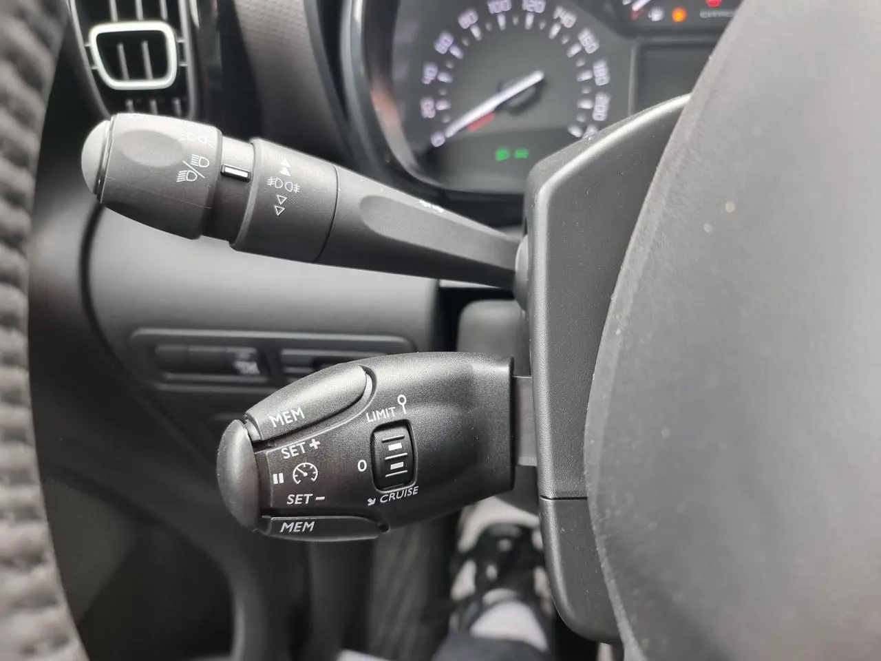 Gros plan sur les commandes de régulateur de vitesse et des phares du tableau de bord d'une Citroën C3 Aircross 2022.