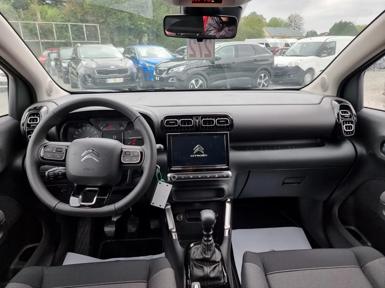 Vue intérieure avant du Citroën C3 Aircross 2022, tableau de bord noir avec écran tactile central et volant multifonction.
